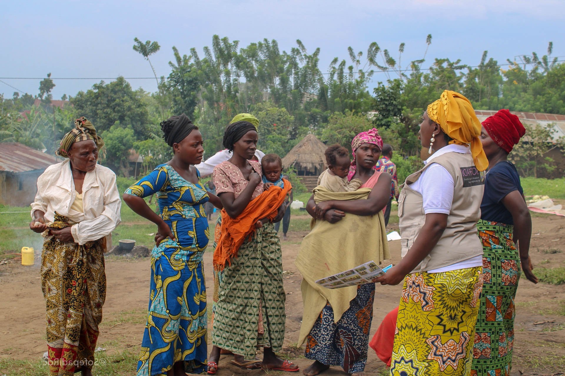 a group of women outside in the Congo listening to a SOFEPADI leader