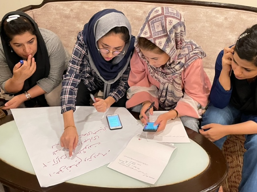 four Afghan women activist sit working together at workshop