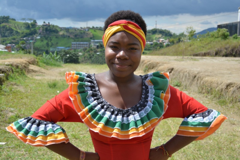 a young Afro-Colombian woman wearing tradition dress smiles directly at the camera