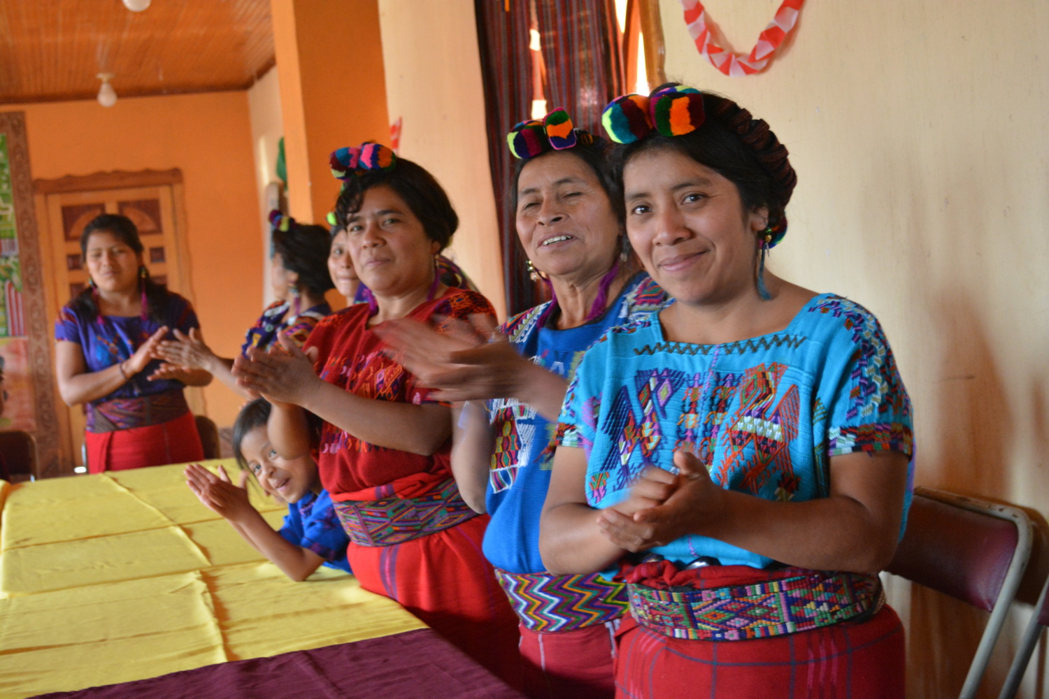 a group of Indigenous Guatemalan women clap at a workshop