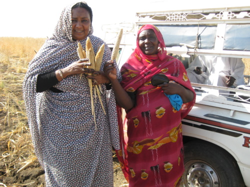 Fatima Ahmed stands holding wheat with her mother Zenab