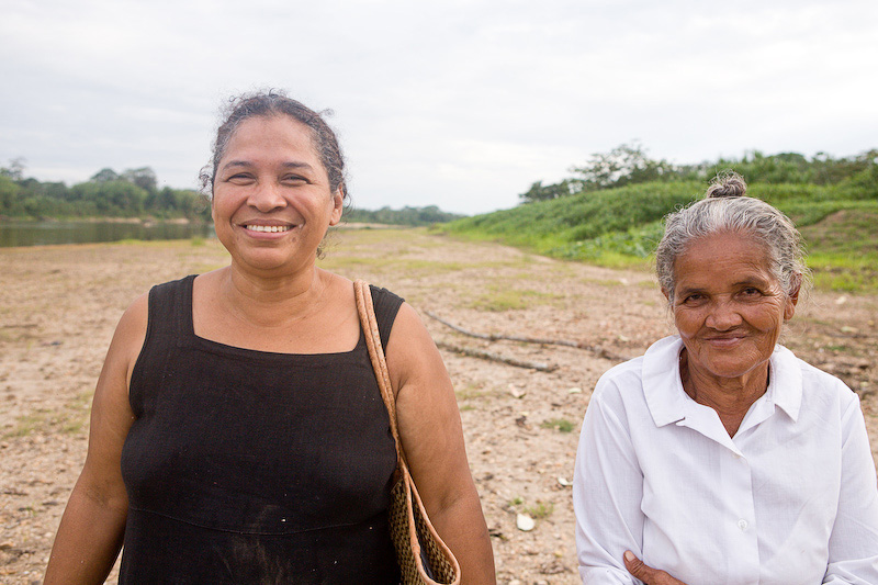 Rose Cunningham stands with an elderly woman on the banks of a river