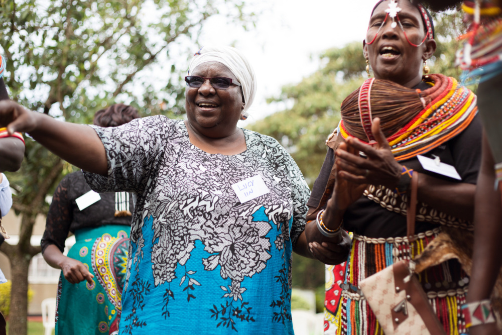 Lucy Mulenkei stands with other Indigenous women who are in traditional clothing