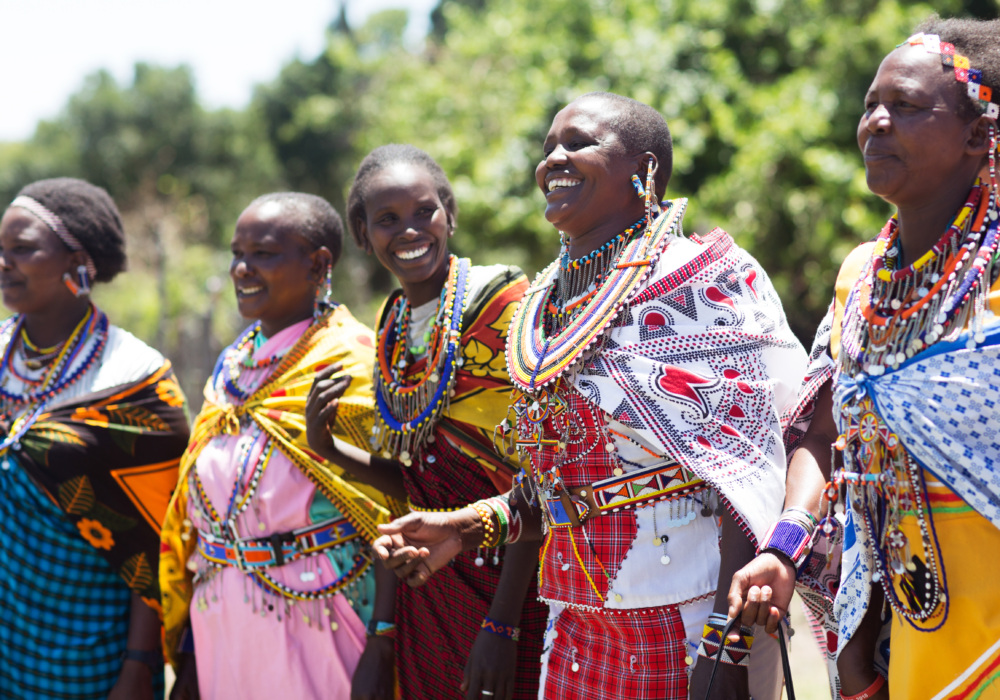 Indigenous women in Kenya dance and laugh together