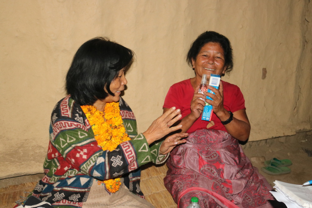 Yasso Bhattachan gives humanitarian supplies to a woman