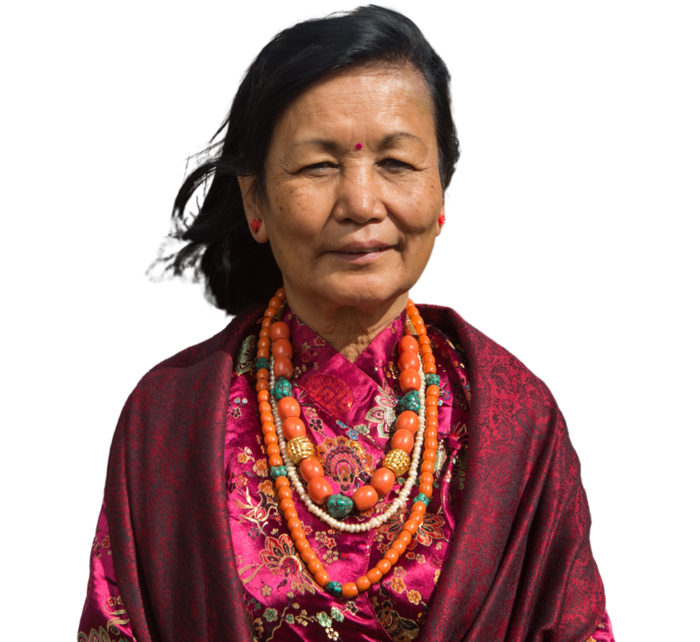 a cutout image of Yasso Bhattachan from the chest up wearing multiple colorful necklaces, a dress and a shawl