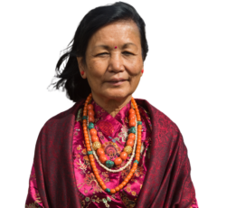 a cutout image of Yasso Bhattachan from the chest up wearing multiple colorful necklaces, a dress and a shawl